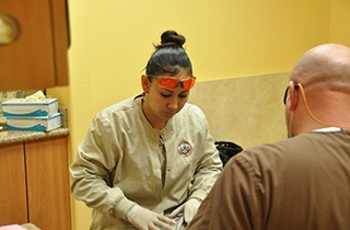 team members cleaning patient's teeth