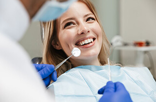 a patient smiling while getting her teeth checked