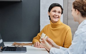 a patient smiling while talking to her dentist about dentures