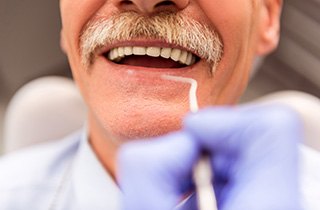 Woman with glasses and white shirt with tooth pain