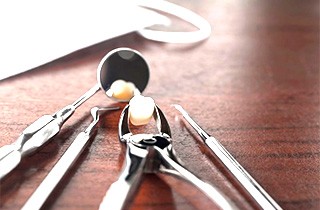 Extracted tooth sitting on wood table next to dental equipment