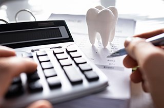 A dental patient calculating the cost of dental implants