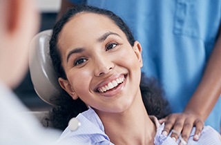 a patient smiling while chatting with her dentist